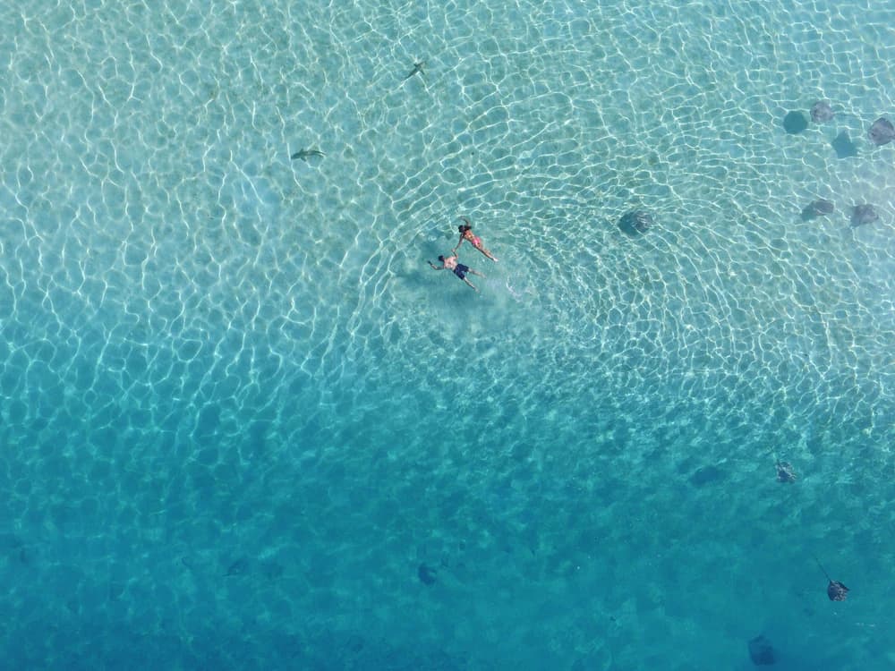 Vue aérienne de deux baigneurs dans un lagon turquoise